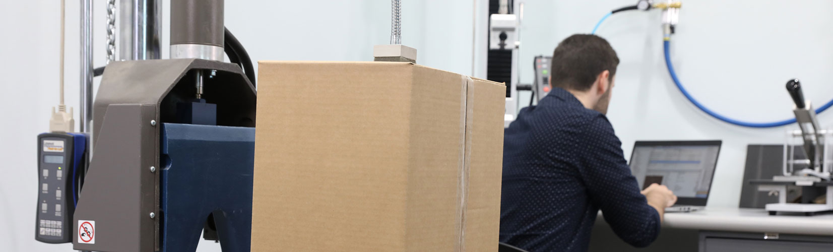 Pregis engineer performing drop test on cardboard box package inside a laboratory