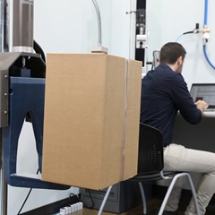 Pregis engineer performing drop test on cardboard box package inside a laboratory