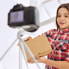 girl in red plaid shirt holding a cardboard box package