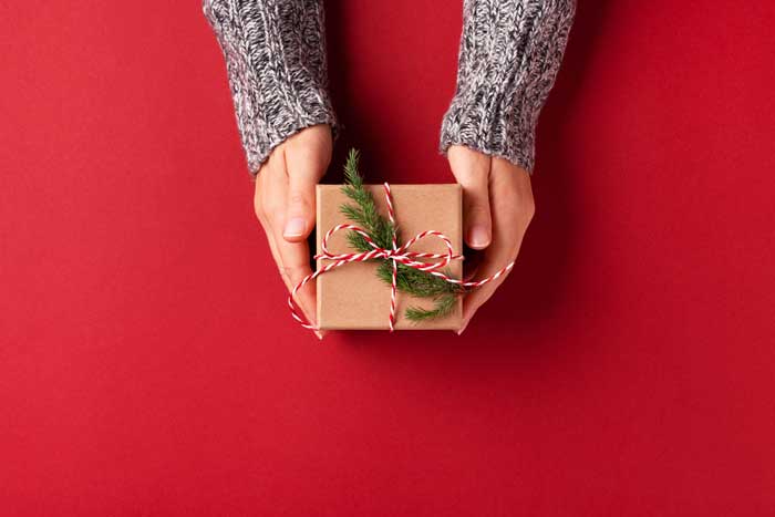 pacco dono natalizio su sfondo rosso