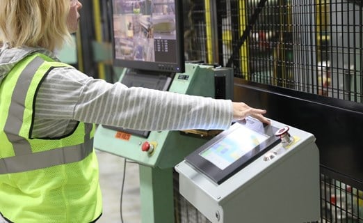 Frau arbeitet an Verpackungsmaschine