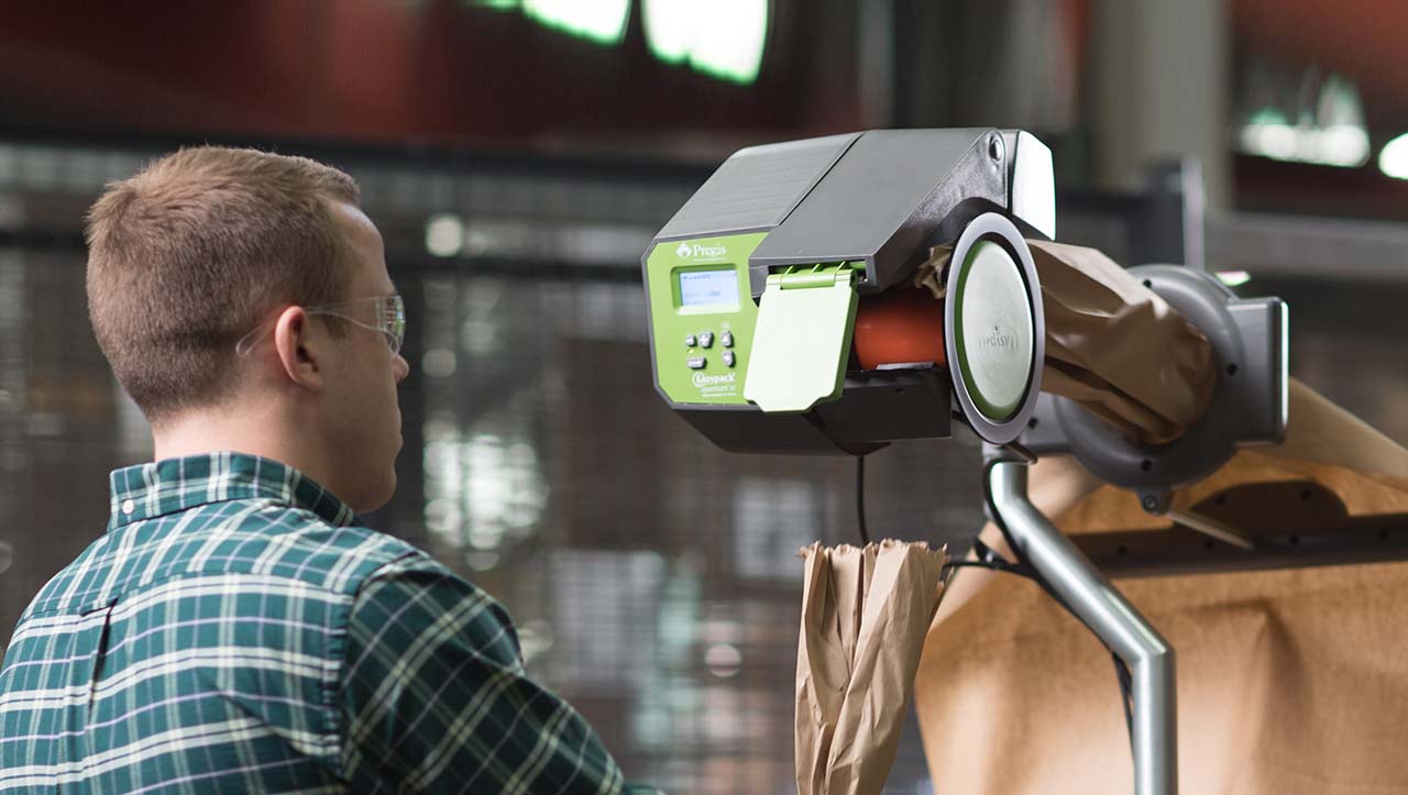 A technician operating a paper packaging system.